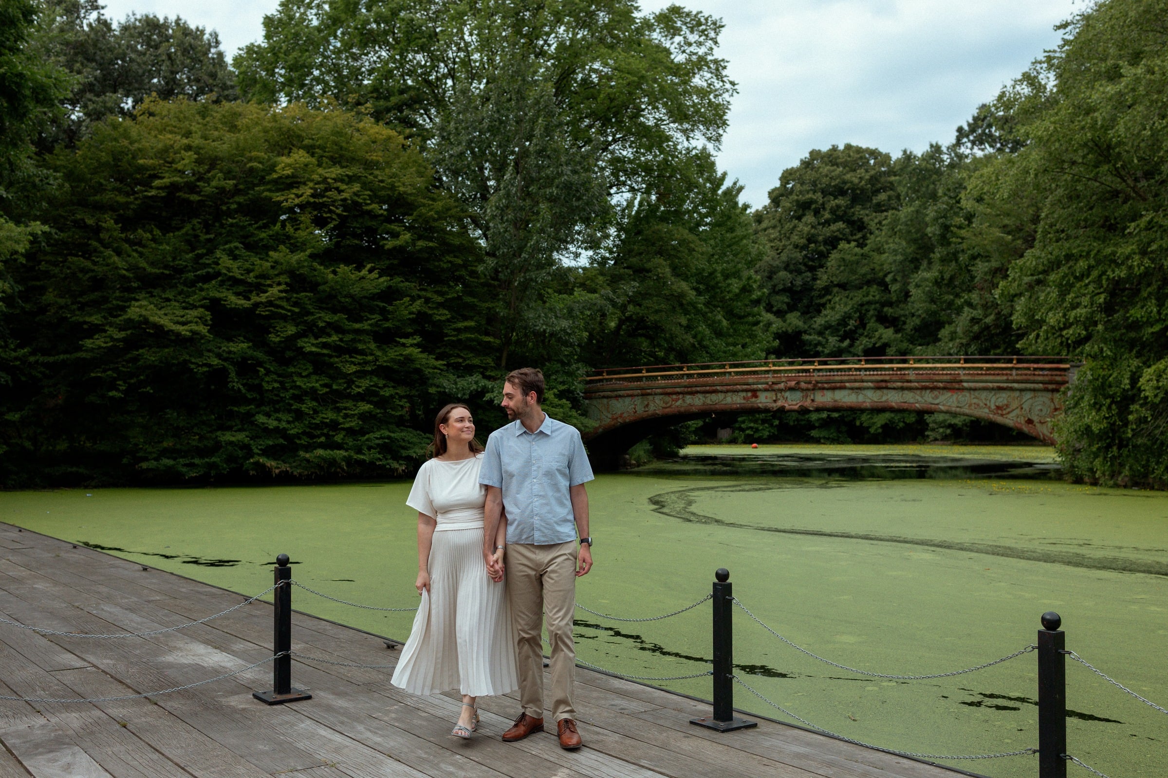 Monika and Haggai walking hand in hand along the boathouse dock in Prospect Park, Brooklyn.