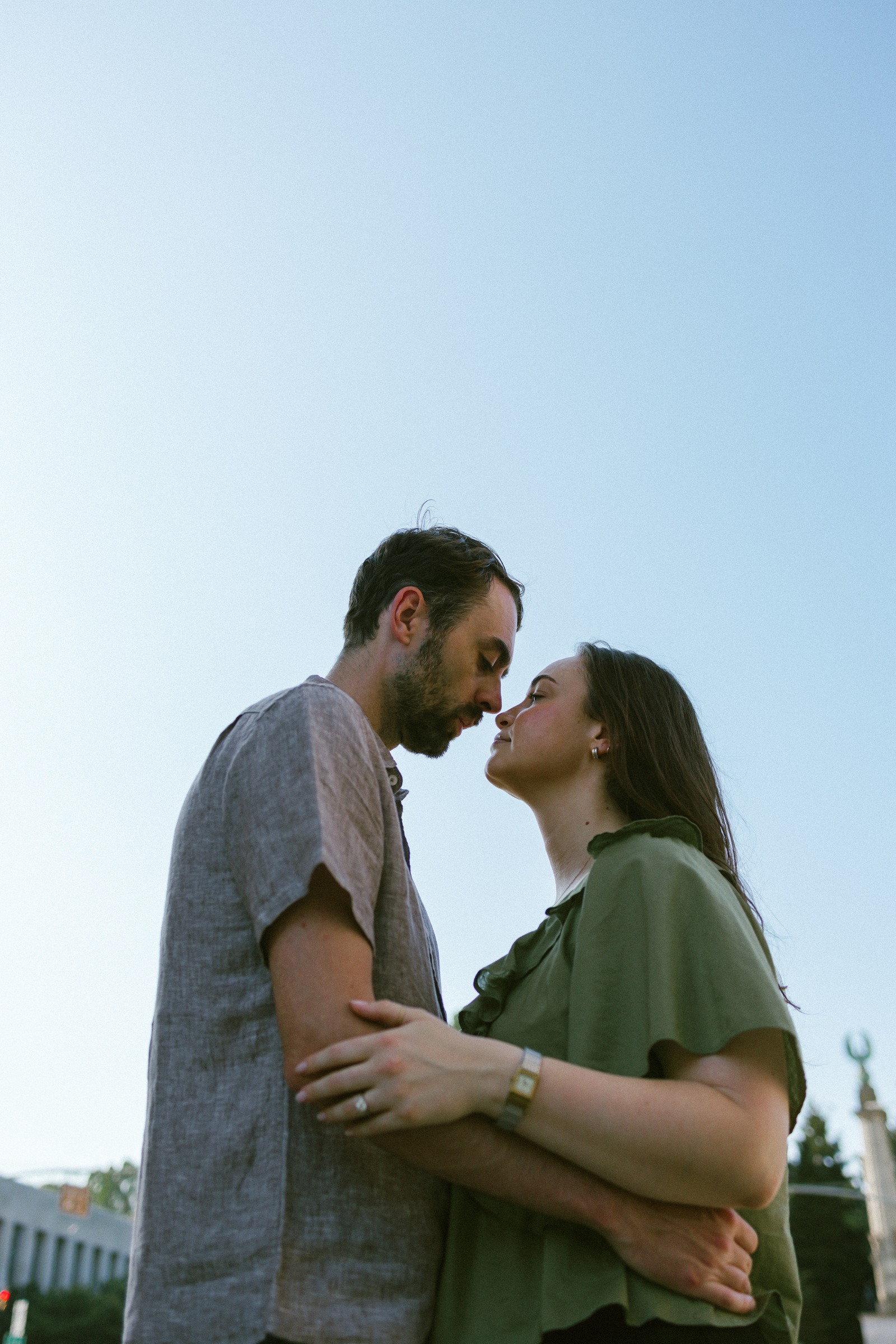 Monika and Haggai standing forehead to forehead against an open evening sky.